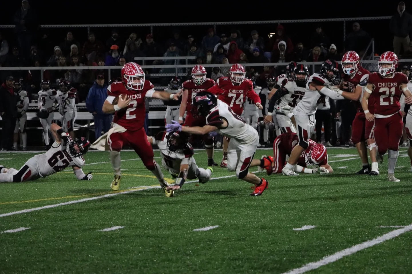Chucks ball carrier running under the lights during a night game